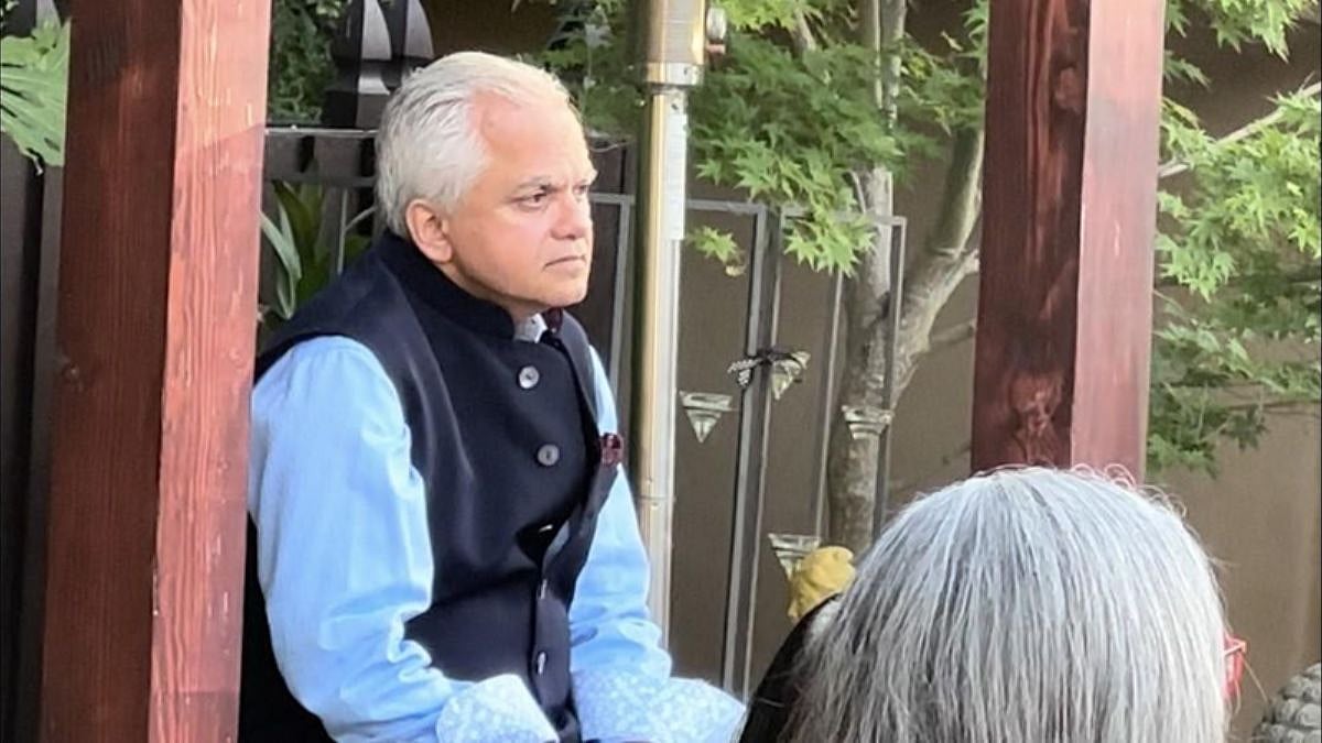The host, Vijay Advani, listens intently to the speaker. 